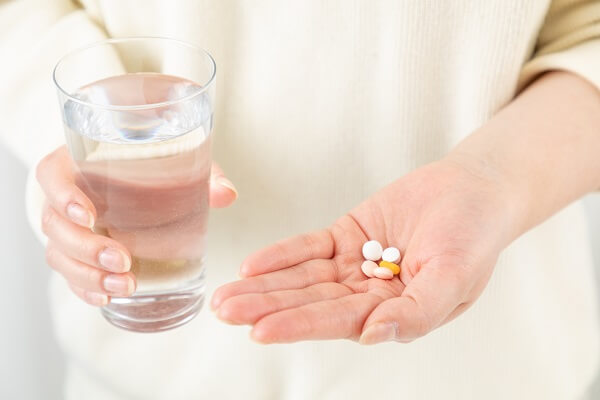 サプリを持つ女性の手